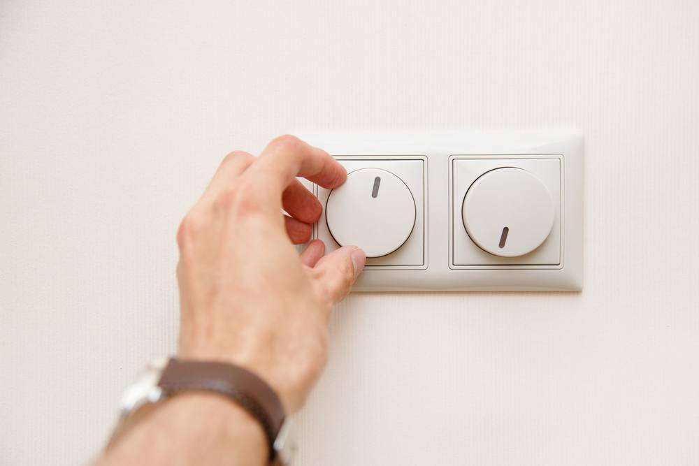 A man adjusting a dimmer switch